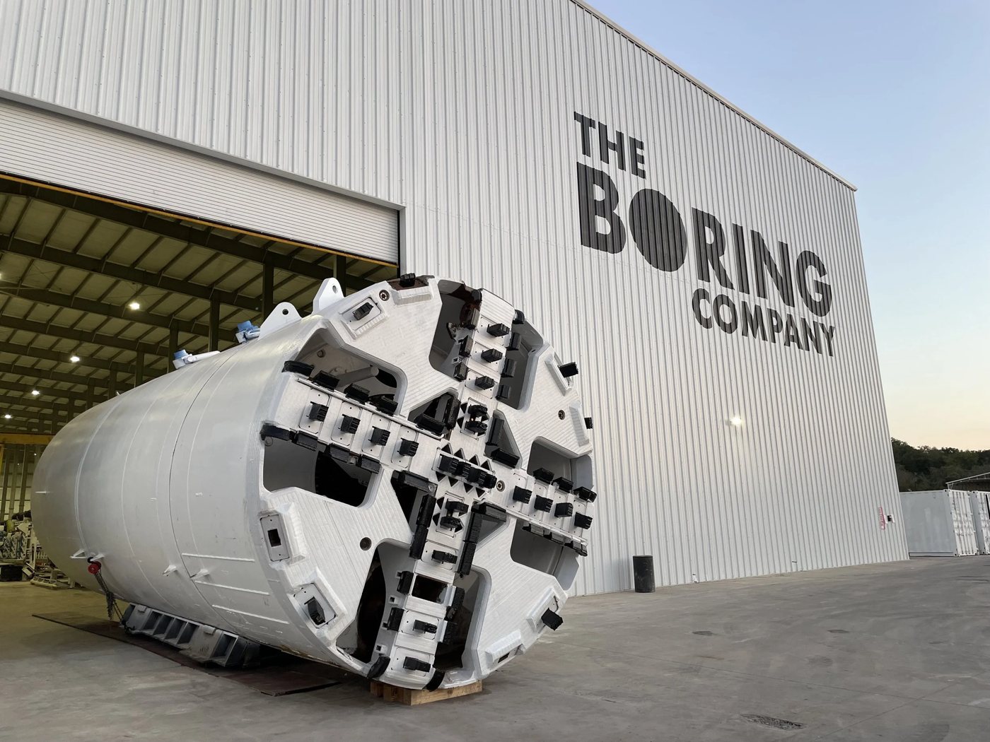 A white tunnel boring machine outside The Boring Company's facility